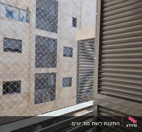 רשת מתכת מותקנת למניעת כניסת יונים במרפסת